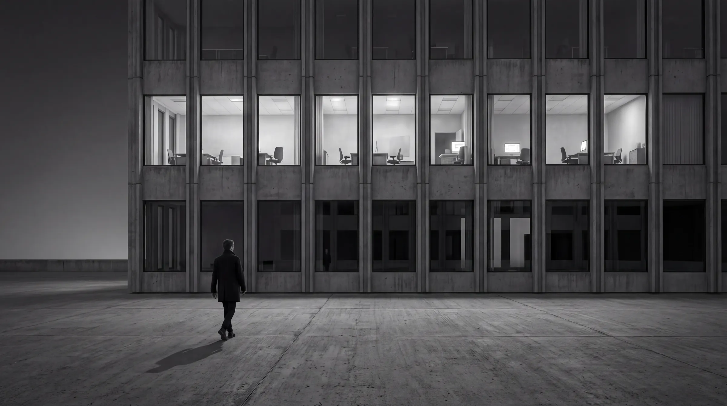 KI-generiertes Bild aus der Serie HUMAN STRUCTURES: In der Dämmerung verlässt ein Mann ein Bürogebäude aus Beton, hinter den Fenstern eines Stockwerks brennt noch Licht in leeren Büros.